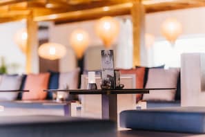 A modern lounge area with a sofa, a coffee table, and a decorative vase. - Ohasis Boutique Suites (Arona)