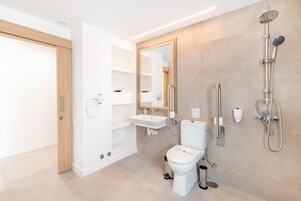 Un baño moderno con inodoro, lavabo y ducha.