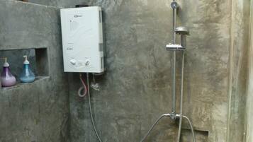 A shower with a handheld showerhead and a wall-mounted control unit.