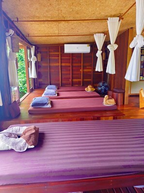 A room with two beds, a fan, and a small table with towels. - Koh Kood Resort (Ko Kood)