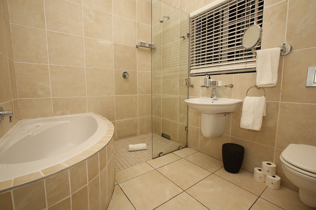 Un baño con bañera, lavamanos, inodoro y zona de ducha.