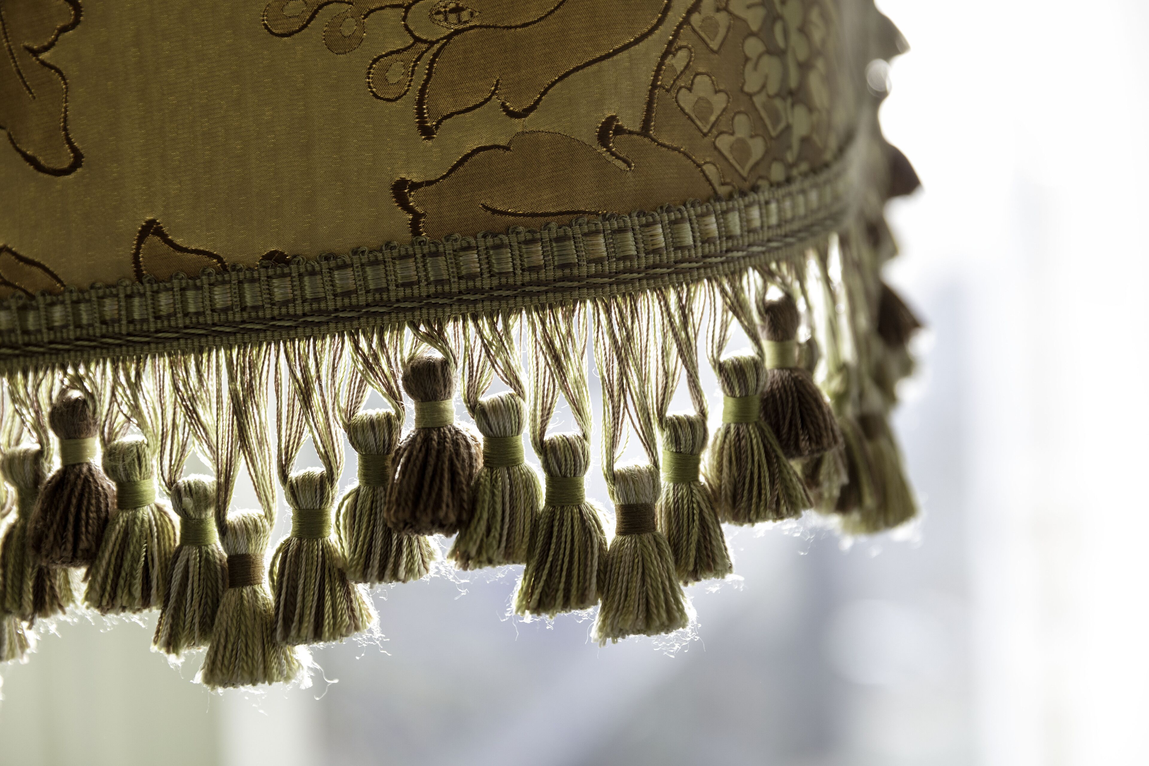 A close-up of a fabric with tassels and a decorative border.