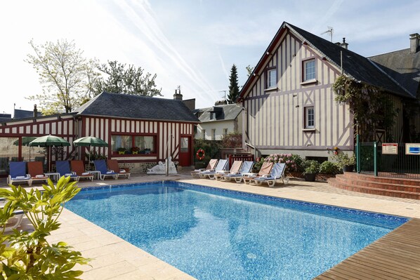 Alberca al aire libre y camastros 