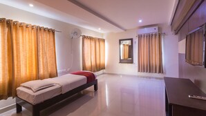 Una habitación de hotel moderna con una cama, un escritorio y un espejo grande.