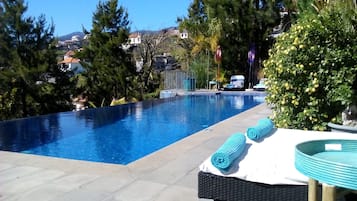 Alberca al aire libre y camastros