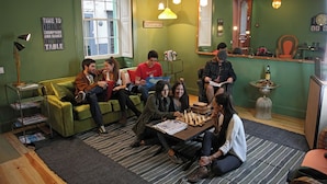 A cozy room with a green wall, a large mirror, and a chess table. - 29 Madeira Hostel (Funchal)