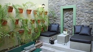 A cozy outdoor seating area with built-in benches and a stone wall backdrop. - 29 Madeira Hostel (Funchal)