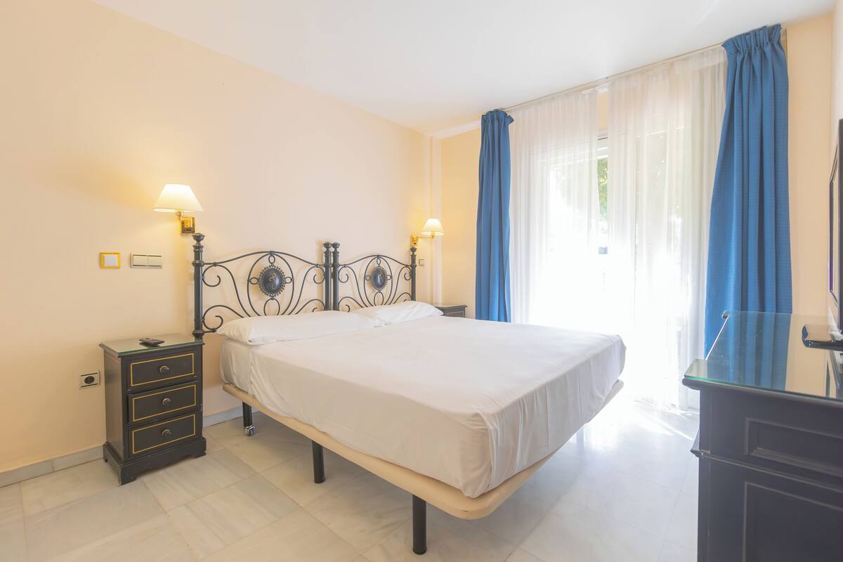Une chambre à coucher avec un lit, des lampes de chevet, une table de chevet et une commode.
