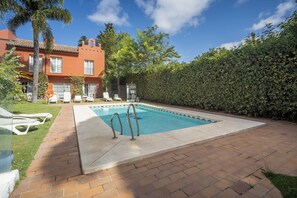 A swimming pool with a brick border, lounge chairs, and a hedge. - Apartamentos Soho Boutique Vistahermosa  (El Puerto de Santa Maria)