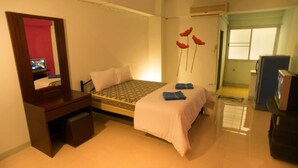 Une chambre à coucher comprenant un lit, un bureau, un miroir et un mur décoré de motifs floraux.