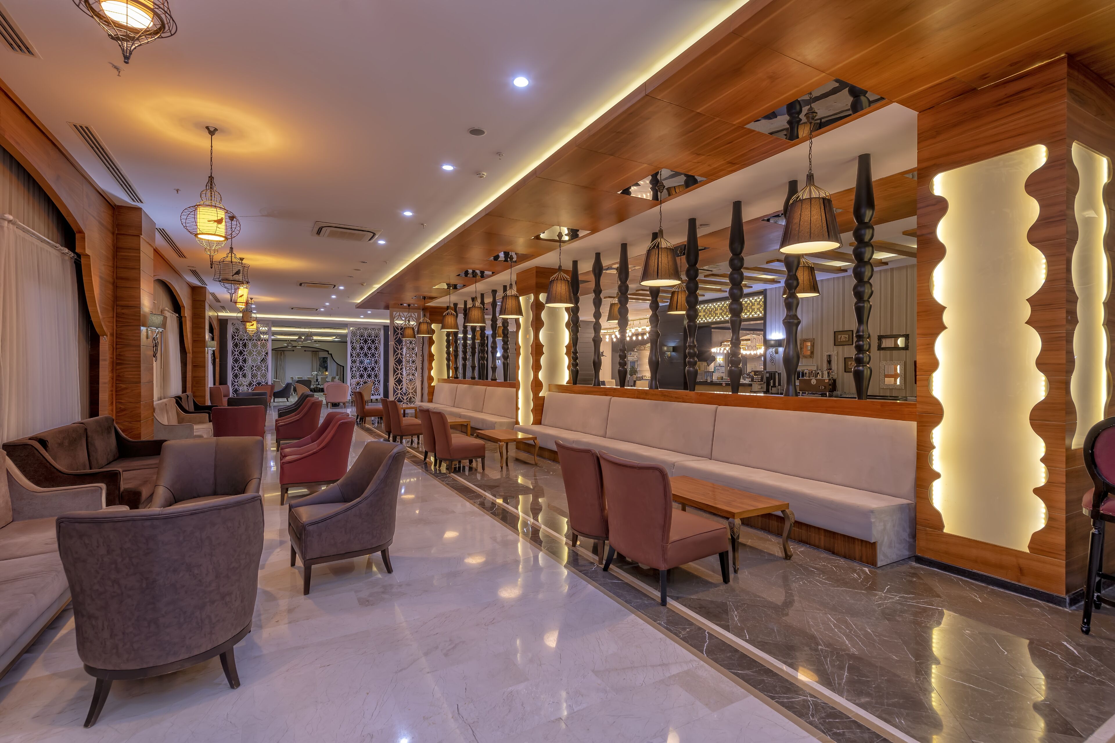 Un moderno vestíbulo de hotel con áreas de estar, una recepción y un bar.