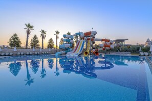 Relax by the pool surrounded by palm trees and lounge chairs.