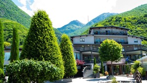 Un hôtel doté d’un balcon, entouré d’une végétation luxuriante et de montagnes.