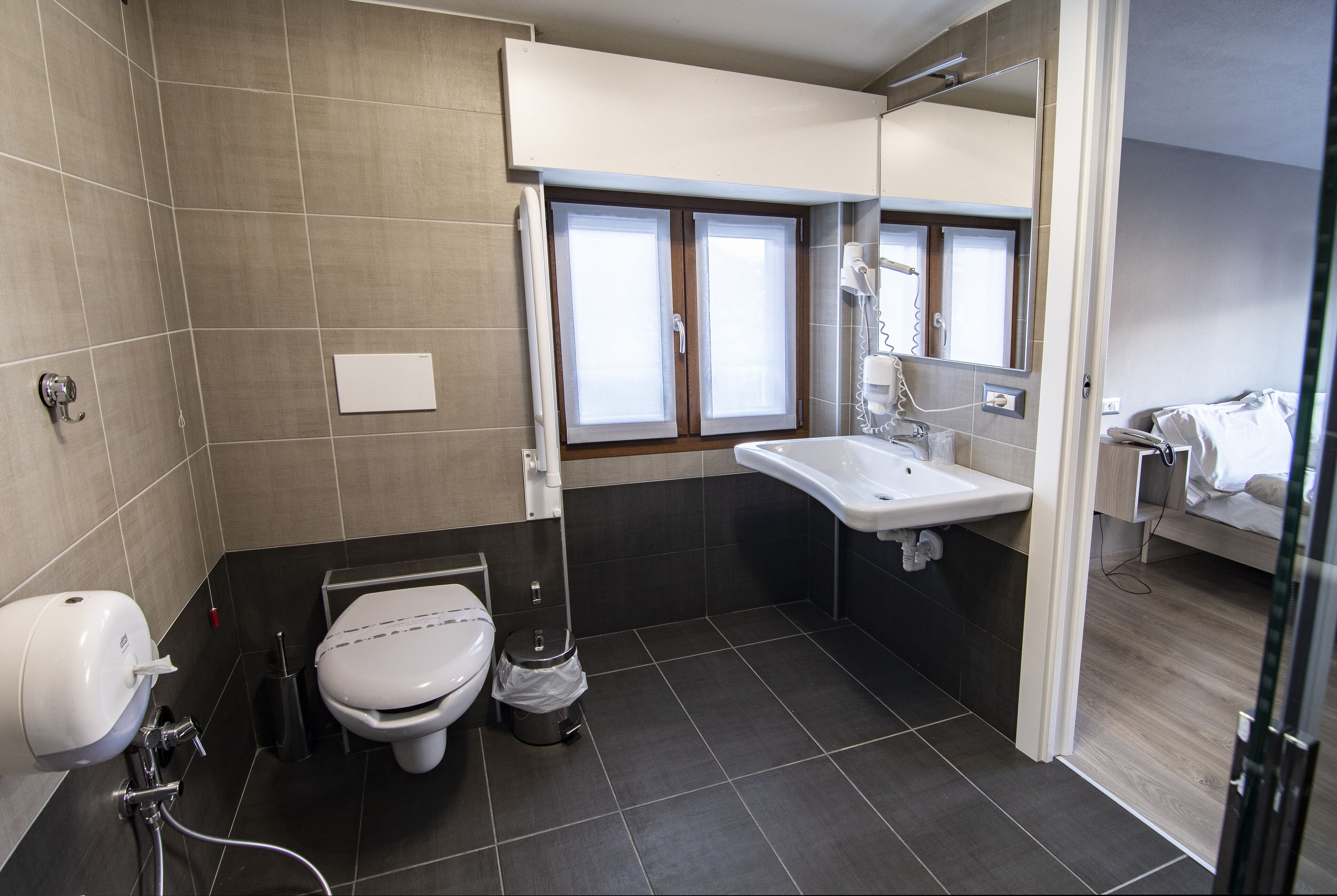 Een moderne badkamer met toilet, wastafel en douche.