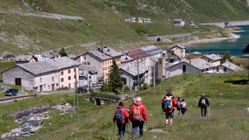 A group of hikers on a mountain trail with a small village in the background.