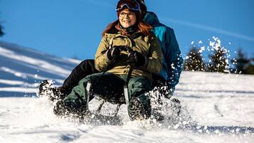 A person sledding down a snowy slope.