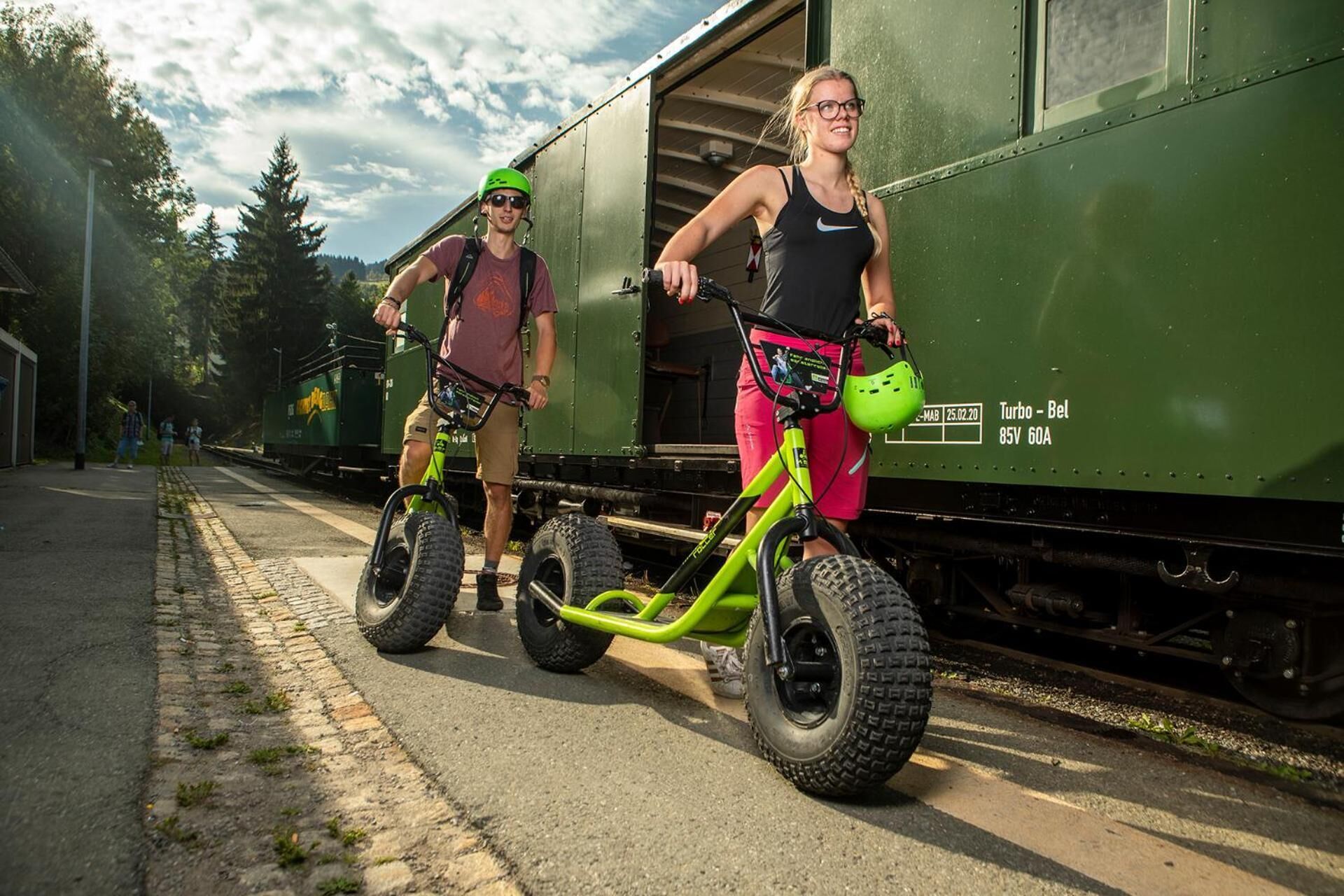 Deux personnes font du vélo sur le quai d’une gare.