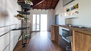 A modern kitchen with wooden flooring, a built-in oven, and a wooden countertop. - La corte sul naviglio (Boffalora Sopra Ticino)