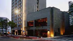 A modern building with a prominent vertical structure and multiple windows. - Ramada by Wyndham Gunsan (Gunsan)