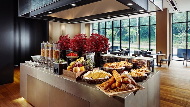 A buffet with various food items and a decorative red plant arrangement. - Ramada by Wyndham Gunsan (Gunsan)
