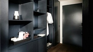 A modern bathroom with a dark wood vanity, a towel hanging on the wall, and a shower area. - Ramada by Wyndham Gunsan (Gunsan)