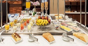 A buffet with various food items including fruits, bread, and beverages. - TRYP by Wyndham São Paulo Guarulhos Airport (Transit Hotel) (Guarulhos)