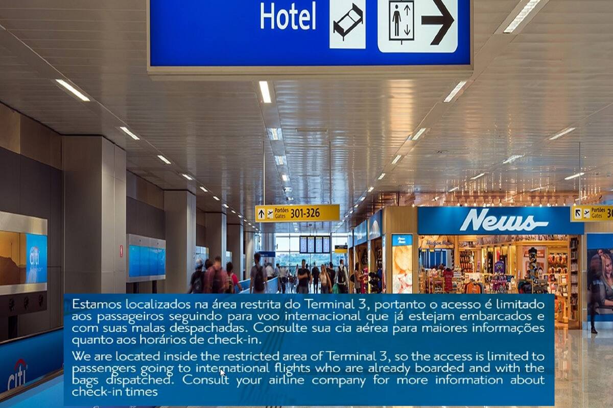 An airport terminal with a sign indicating the direction to the hotel and gates.