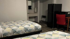 A room with a bed, a desk, a chair, a refrigerator, and a microwave. - Studio 6 Suites Hot Springs, AR (Hot Springs)