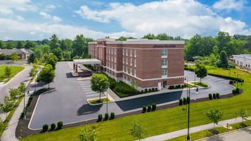 A large brick building with a parking lot and a covered walkway.