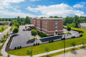A large brick building with a parking lot and a covered walkway. - Hampton Inn & Suites New Albany Columbus (New Albany)