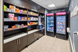 A snack vending area with various snack options and a refrigerated section with beverages.