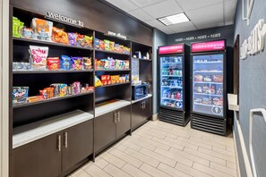 A snack vending area with various snack options and a refrigerated section with beverages. - Hampton Inn & Suites New Albany Columbus (New Albany)