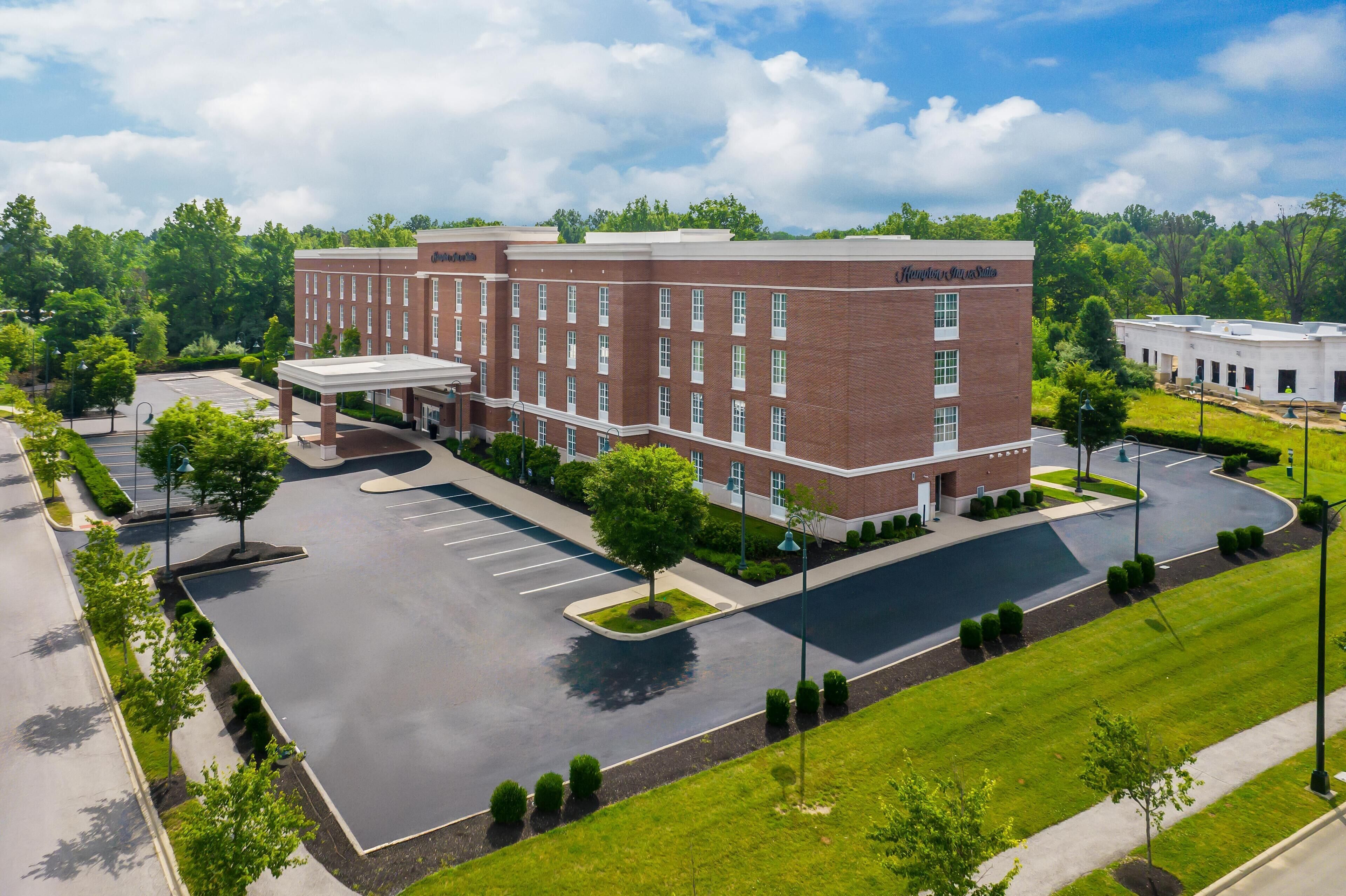 A large brick building with a covered entrance and a parking lot.