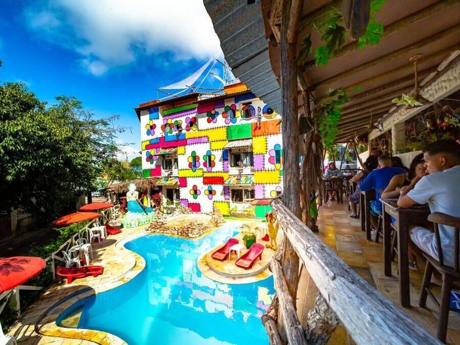 A colorful building with a pool and outdoor seating.