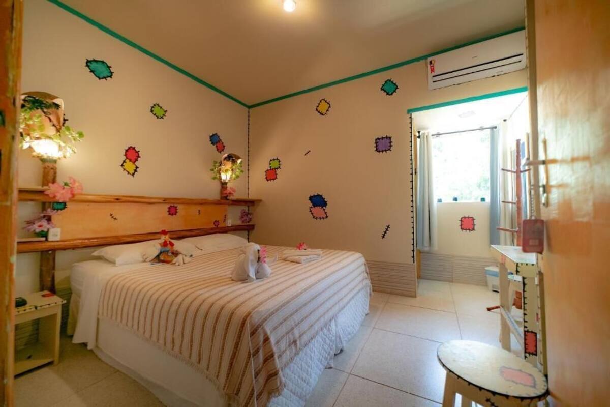 Un dormitorio con una cama, una mesita de noche, un tocador y una ventana.