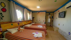 A hotel room with two beds, a window with curtains, a television on the wall, and a small table with a chair. - Pousada das Galinhas (Ipojuca)
