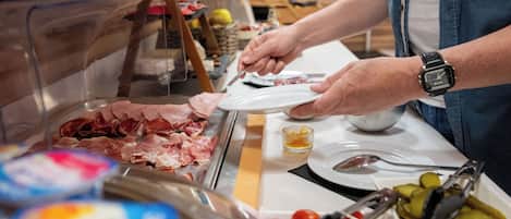 Un bufé con diferentes carnes y acompañamientos.
