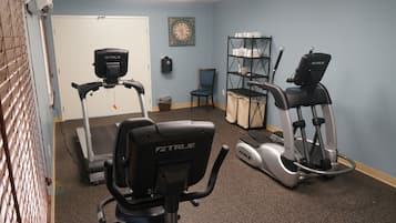 A home gym with a treadmill, elliptical, and exercise bike.