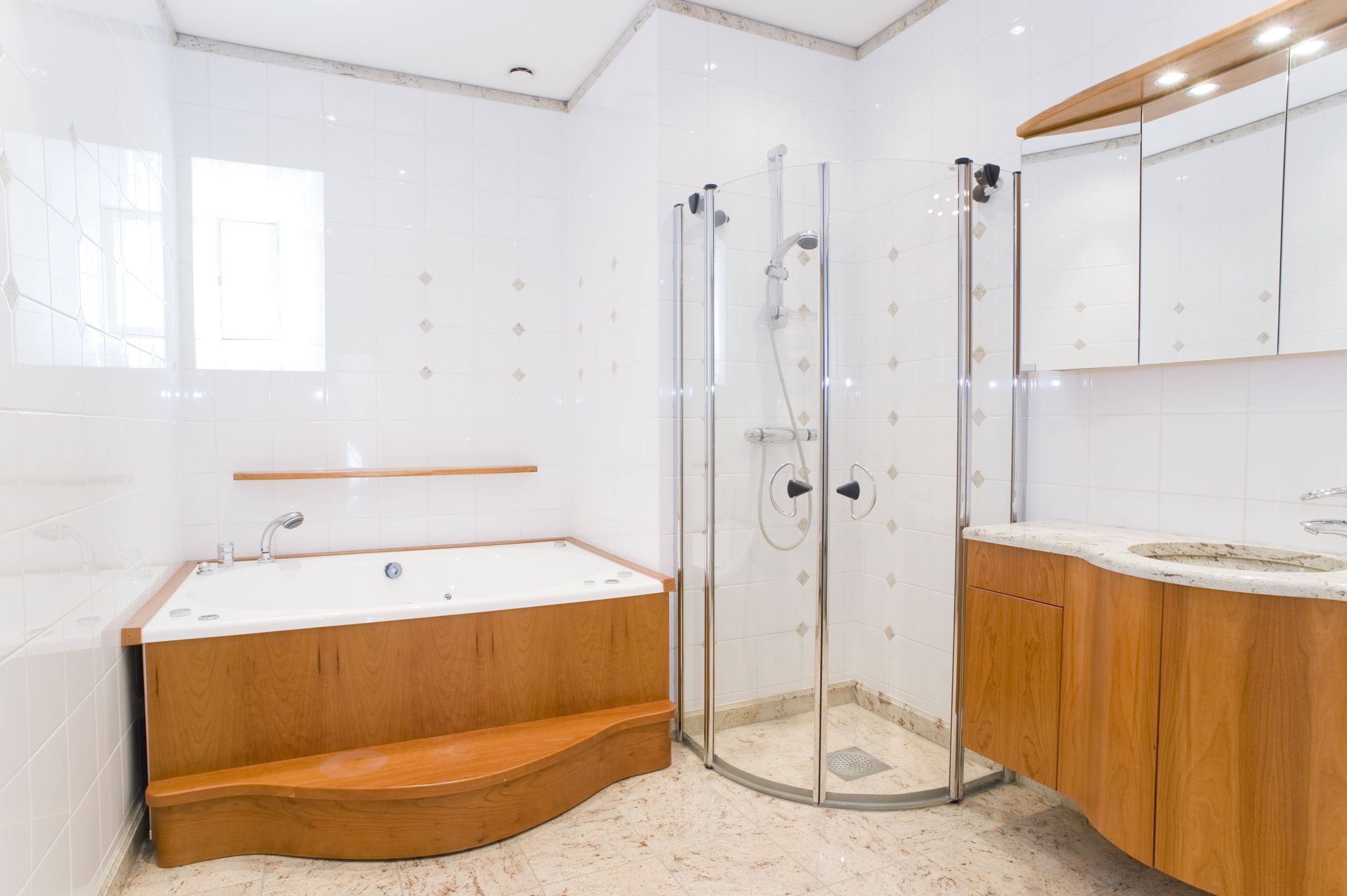 Ein modernes Badezimmer mit einer freistehenden Badewanne, einer begehbaren Dusche mit Glaswand und Holzschränken.