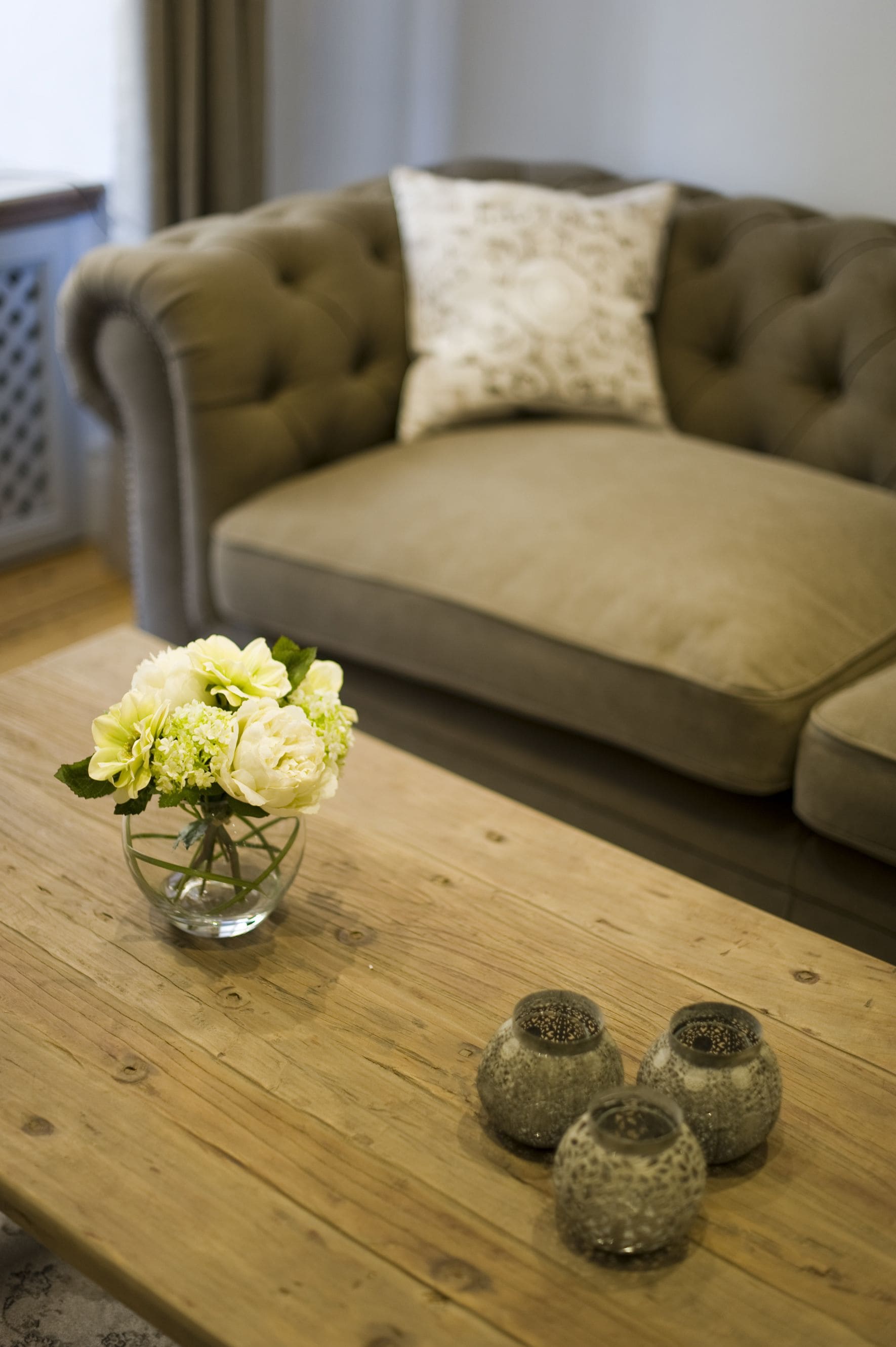 Una mesa de madera con un florero y tres pequeños floreros.