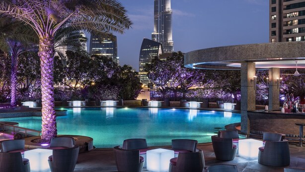 A pool area with lounge chairs and a view of the Burj Khalifa. - Shangri-La Residences and Apartments (Dubai)