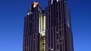 A tall, modern skyscraper with a distinctive architectural design, featuring a central core and two symmetrical towers. - Shangri-La Residences and Apartments (Dubai)
