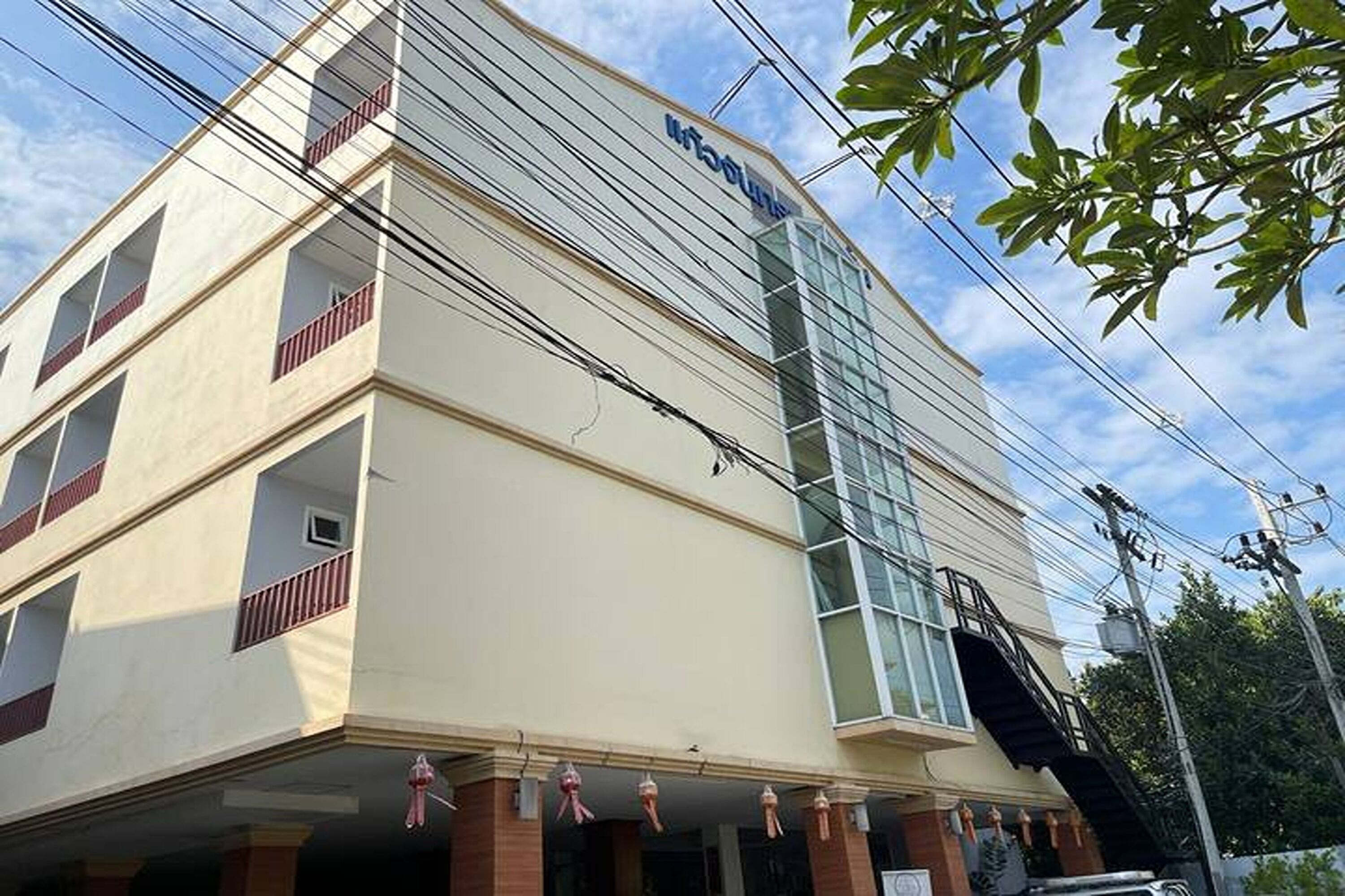 A multi-story hotel with a modern facade, large windows, and a visible staircase.