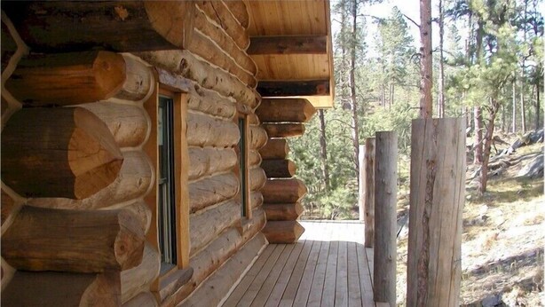 A log cabin with a wooden deck and windows. - Papoose (Custer)