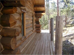 A log cabin with a wooden deck and windows. - Papoose (Custer)