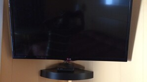 Ein Flachbildfernseher an einer Holzwand befestigt.