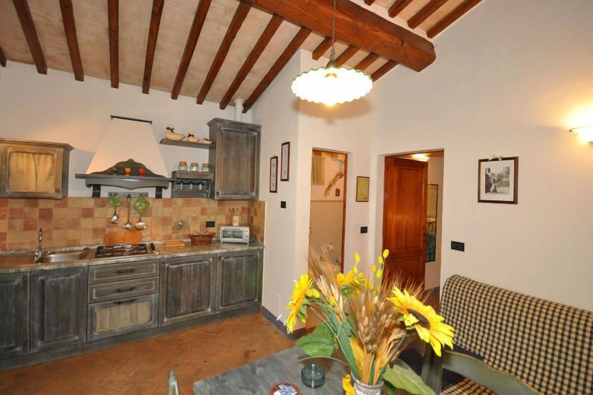 A kitchen with wooden cabinets, a tiled backsplash, and a hanging light fixture.
