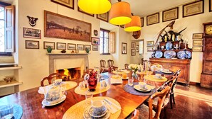 A dining room with a wooden table set for a meal, surrounded by chairs. - Il Principe (Manciano)