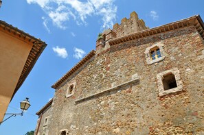 A historic stone building with a prominent tower and arched windows. - Marsilia (Manciano)