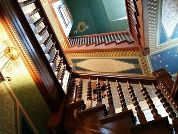 A staircase with ornate balusters and a patterned ceiling.